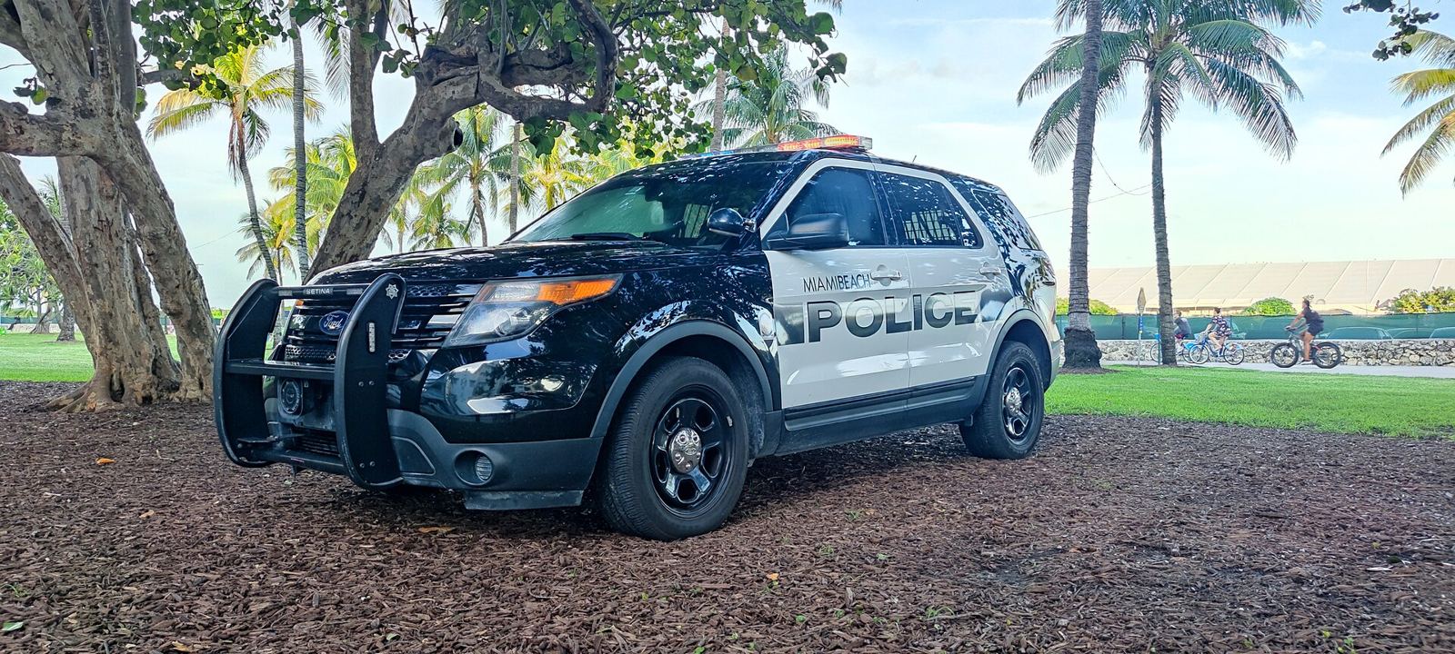 A Miami Beach Police SUV parked under trees by the beach